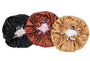 Three velvet hair bonnets in black, brown, and gold on a white background