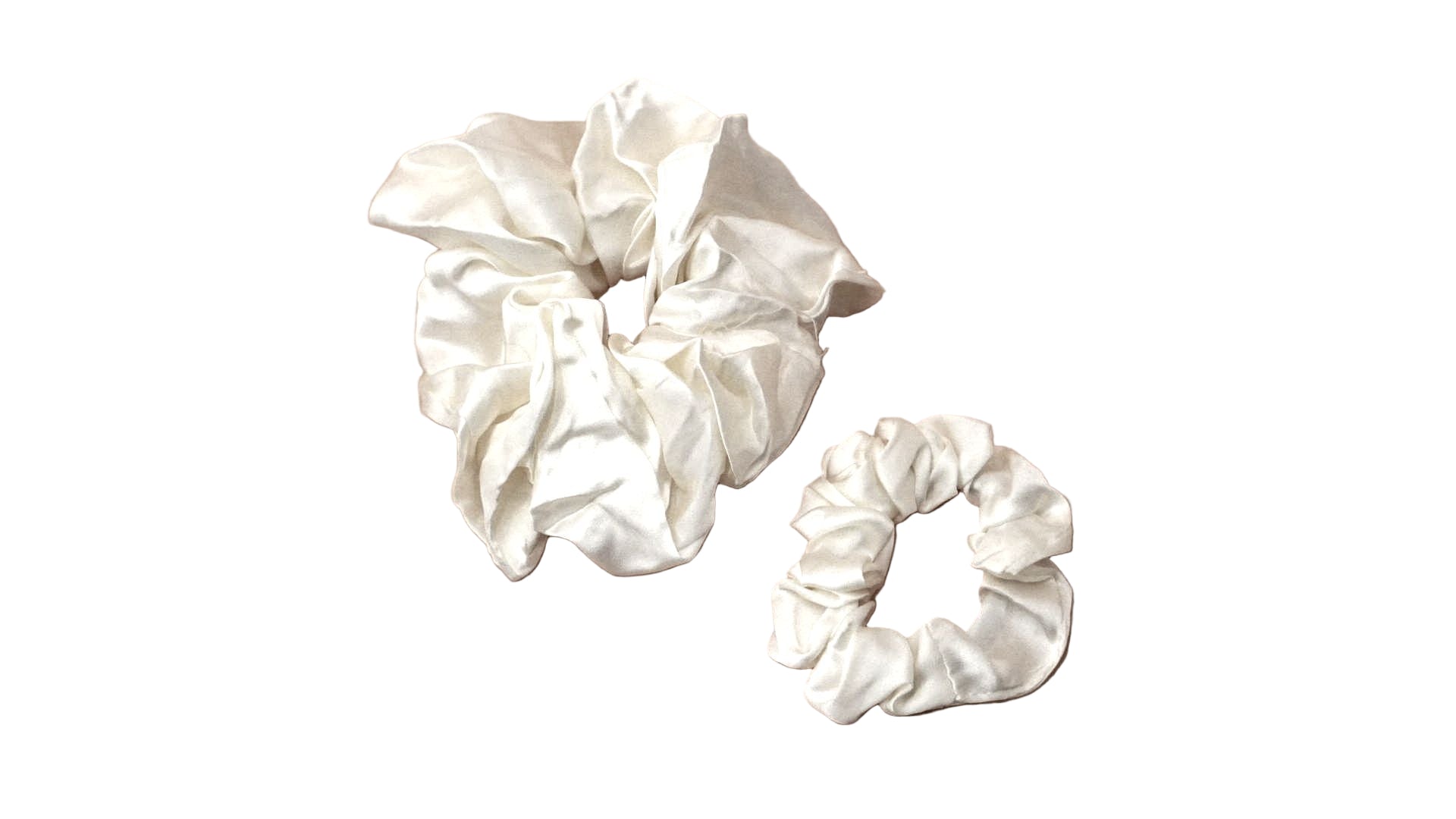 Two white scrunchies on a beige background