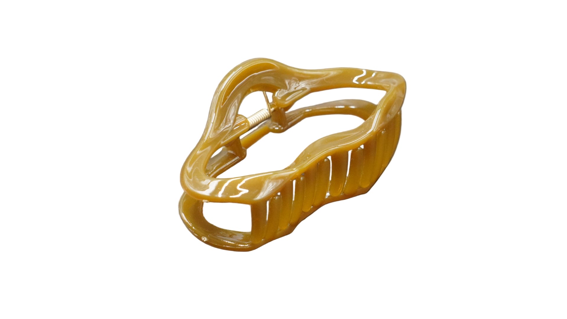 Yellowish-brown hair clip on a gray background