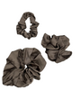 Three Cashmere color scrunchies on a light gray background