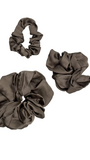 Three Cashmere color scrunchies on a light gray background