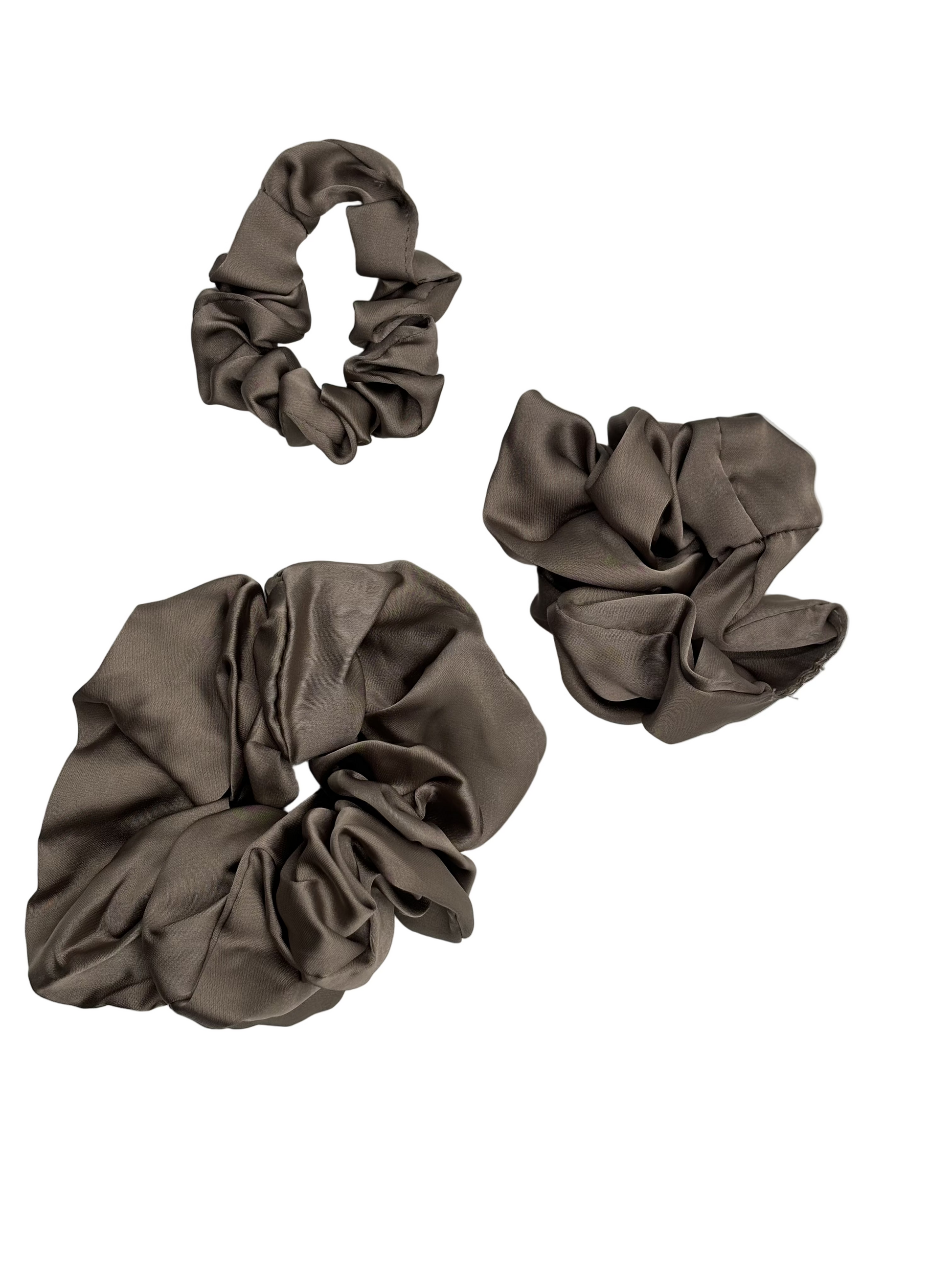 Three Cashmere color scrunchies on a light gray background